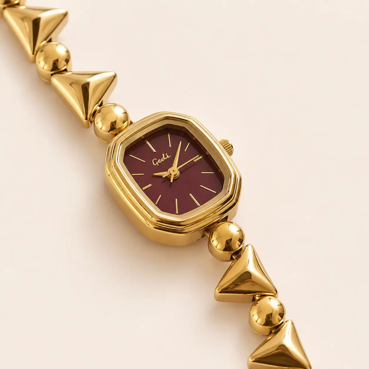 MAVI Colette burgundy gold watch styled on brown fabric
